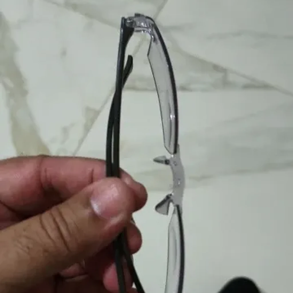 Dłoń taty Ewy trzymająca nowe okulary w domu